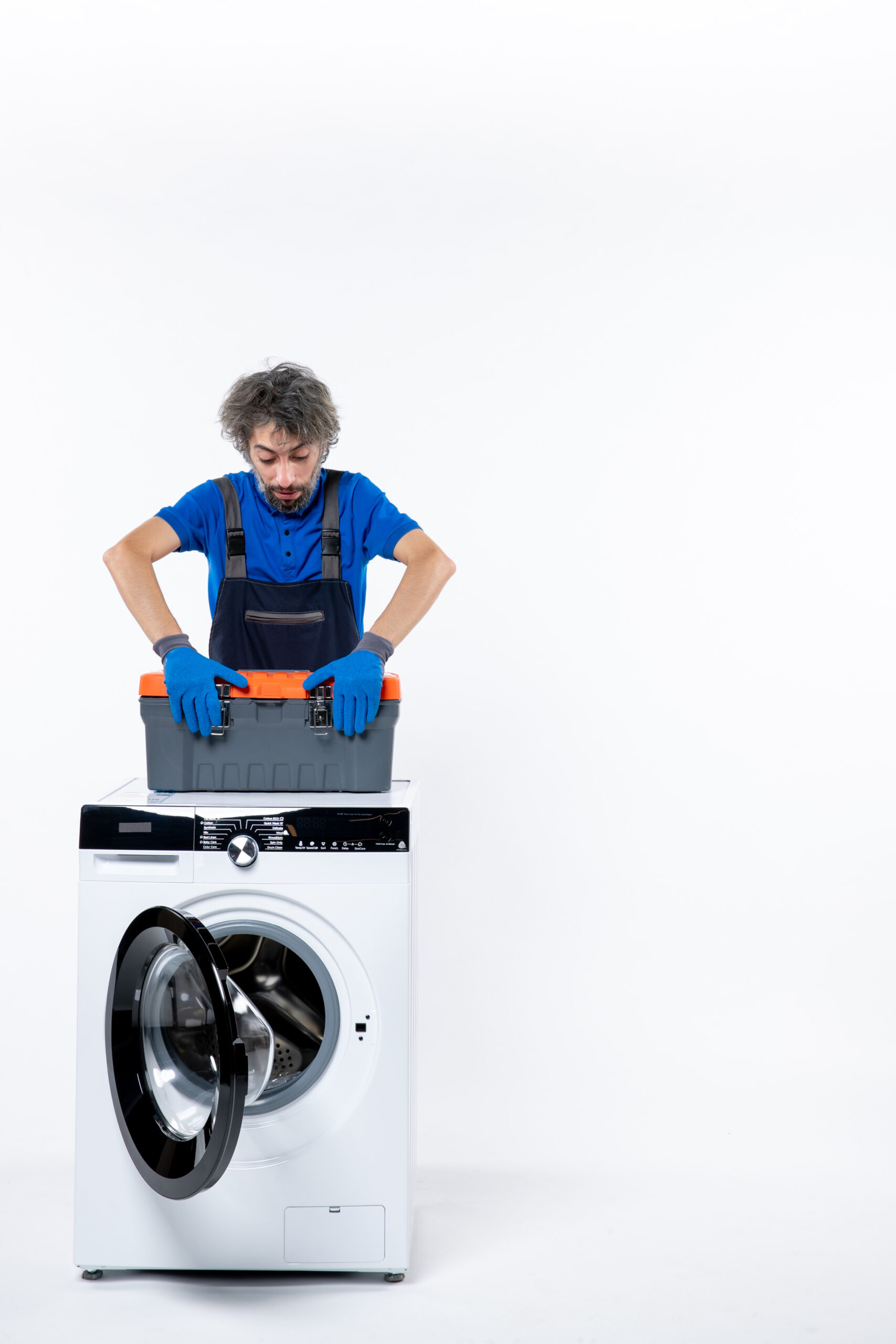 front-view-young-repairman-closing-tools-bag-washing-machine-white-wall
